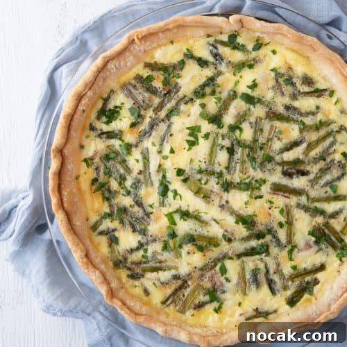 asparagus quiche sitting on a blue tea towel.