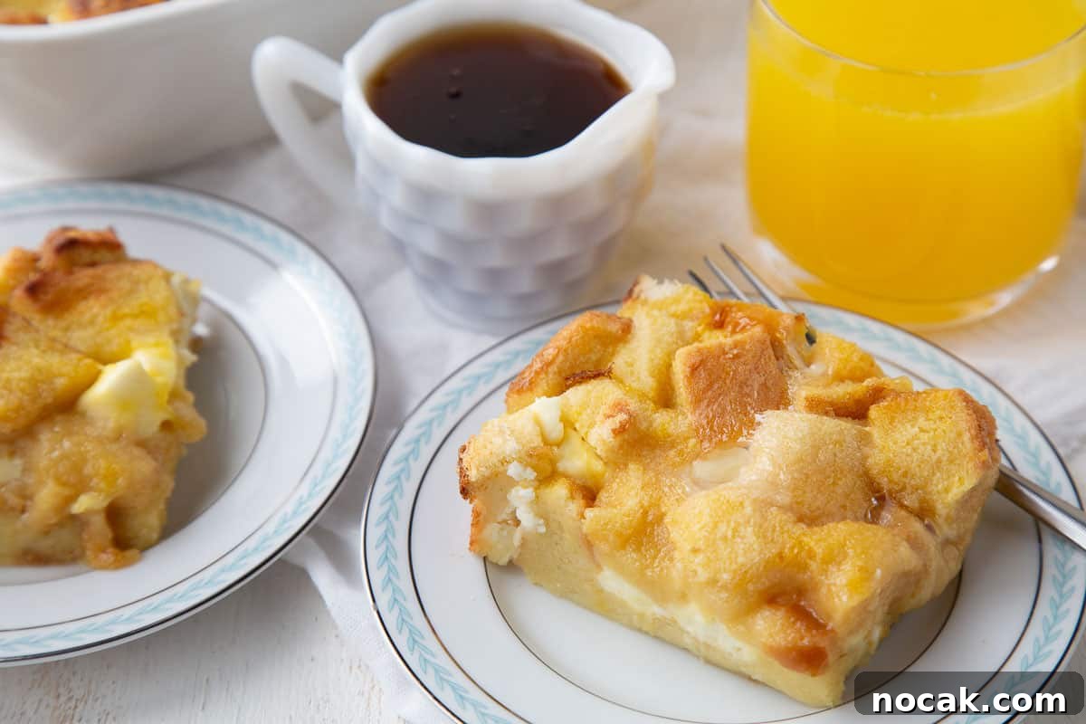 Baked Stuffed French Toast Casserole with Creamy Filling 8 slices of french toast casserole on plates next to a mini pitcher of maple syrup and a glass of orange juice.