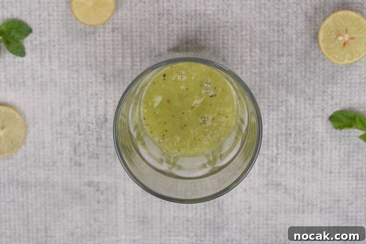 Refreshing Kiwi Soda Recipe: Sparkling Homemade Drink 5 Kiwi mixture added to a glass.
