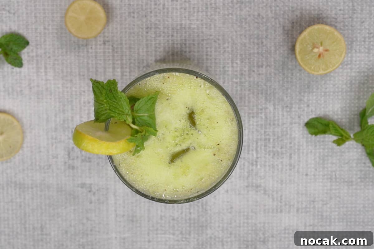 Refreshing Kiwi Soda Recipe: Sparkling Homemade Drink 7 Ready kiwi soda garnished with lime slice and mint leaves.