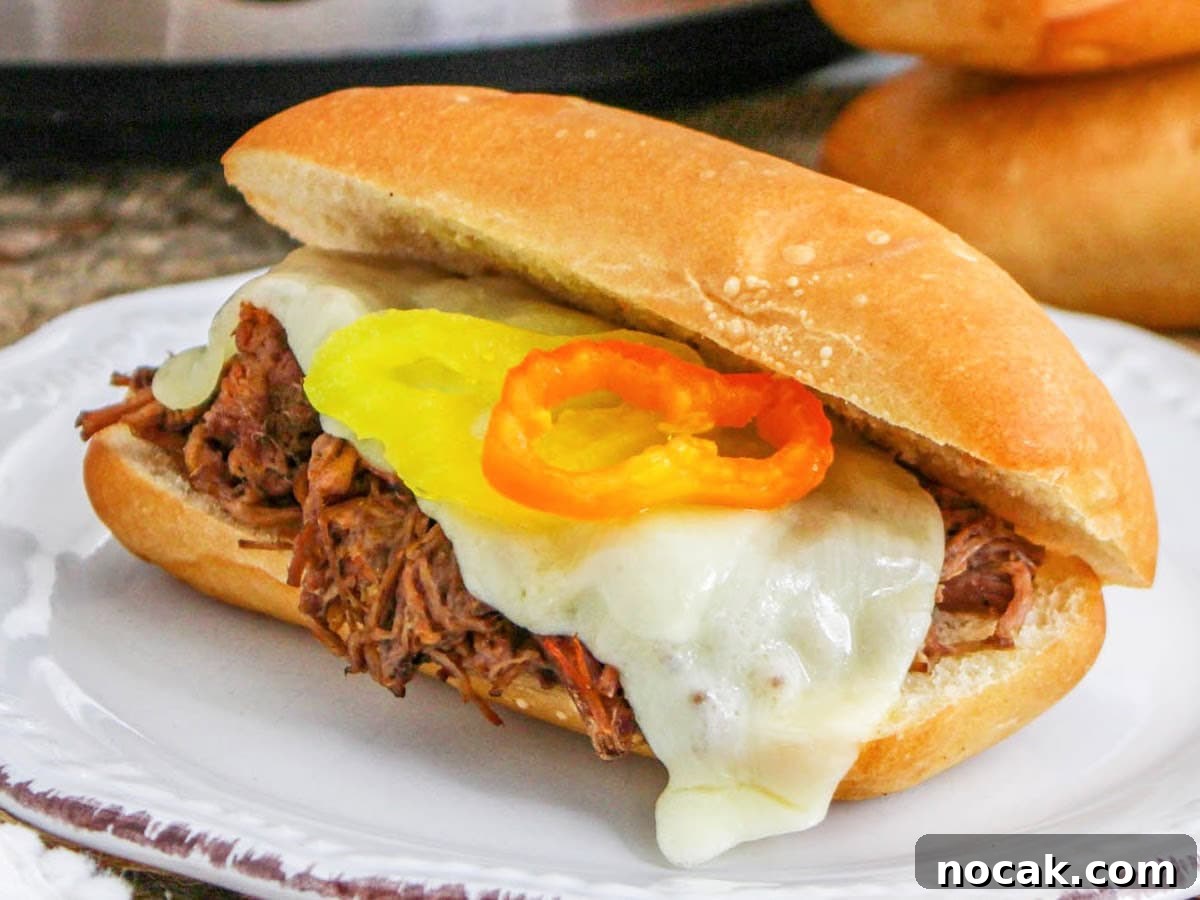 Slow Cooker Italian Beef Sandwich Recipe for Tender, Flavorful Meat 6 Crockpot Italian beef hoagies melted provolone and garnished with pepperoncini peppers on a toasted roll.
