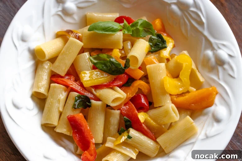 Roasted bell pepper pepper sauce with pasta served in a white dish.