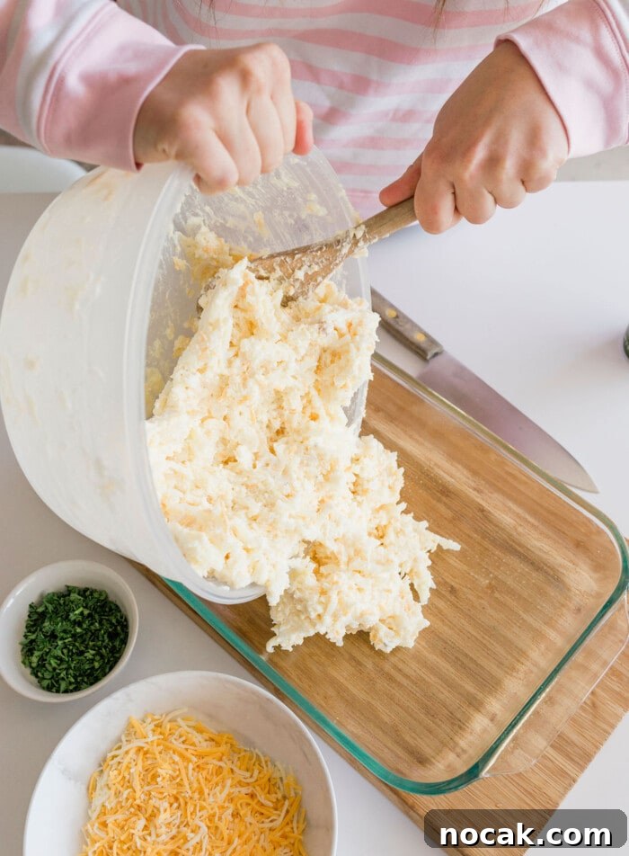 Cracker Barrel Hashbrown Casserole Copycat Recipe 15 A glass baking dish filled with prepared hashbrown casserole ready for the oven.
