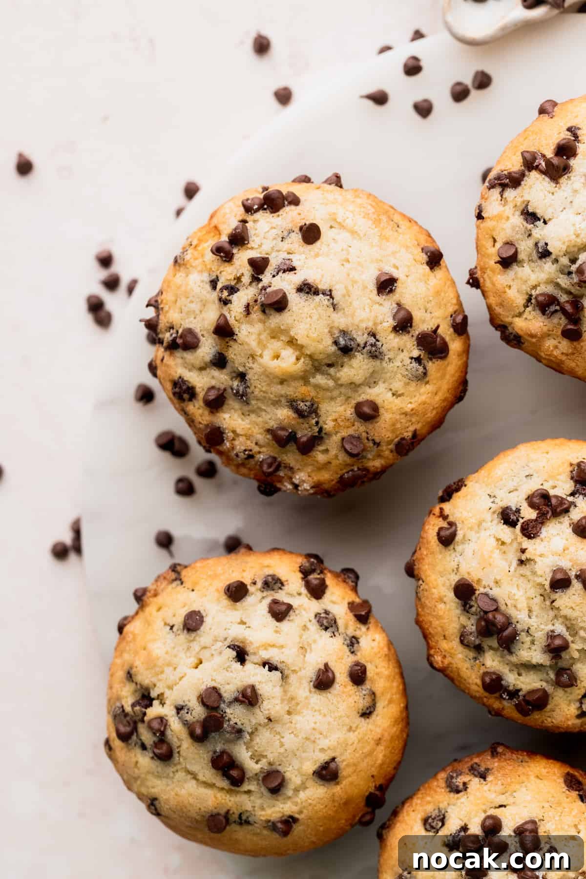 Top view of chocolate chip buttermilk muffins on a marble board.