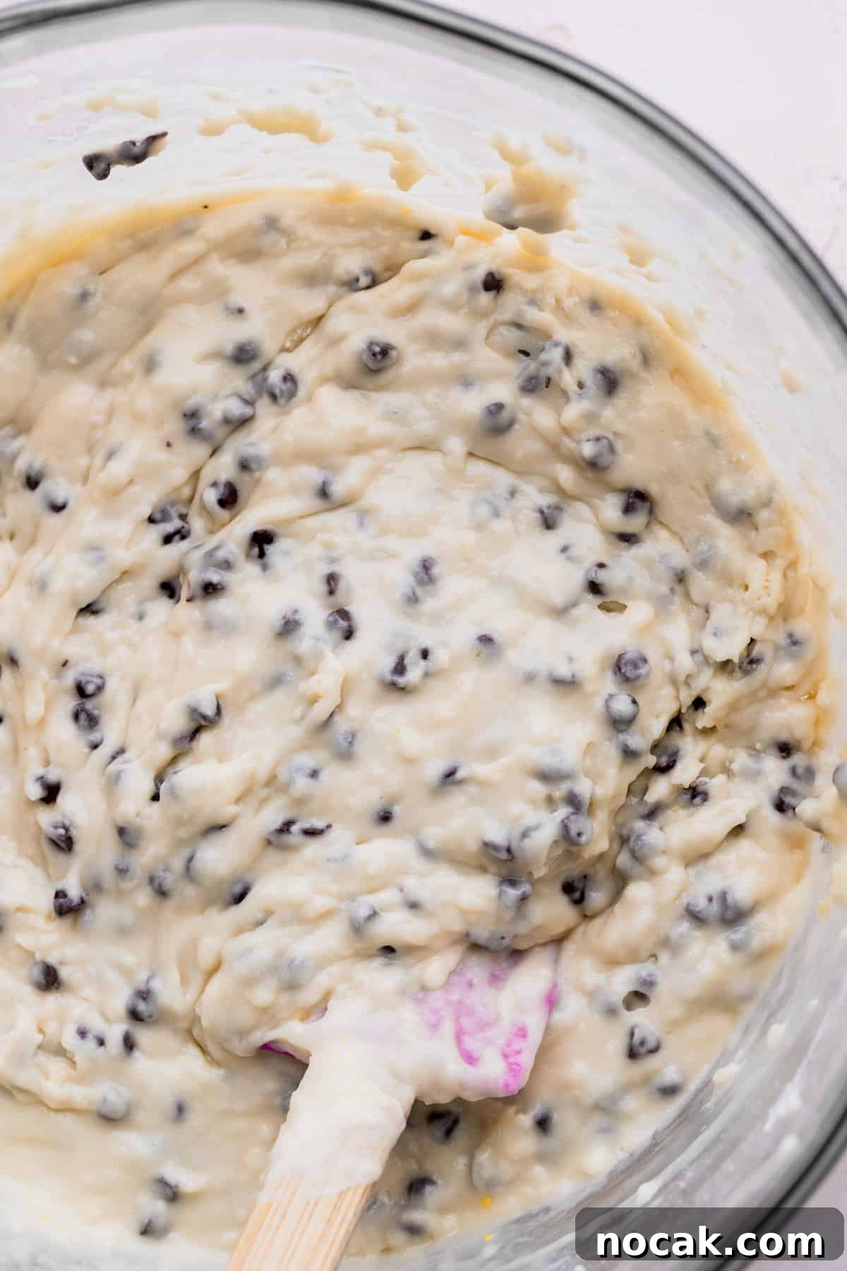 Chocolate chip muffin batter in a glass bowl.