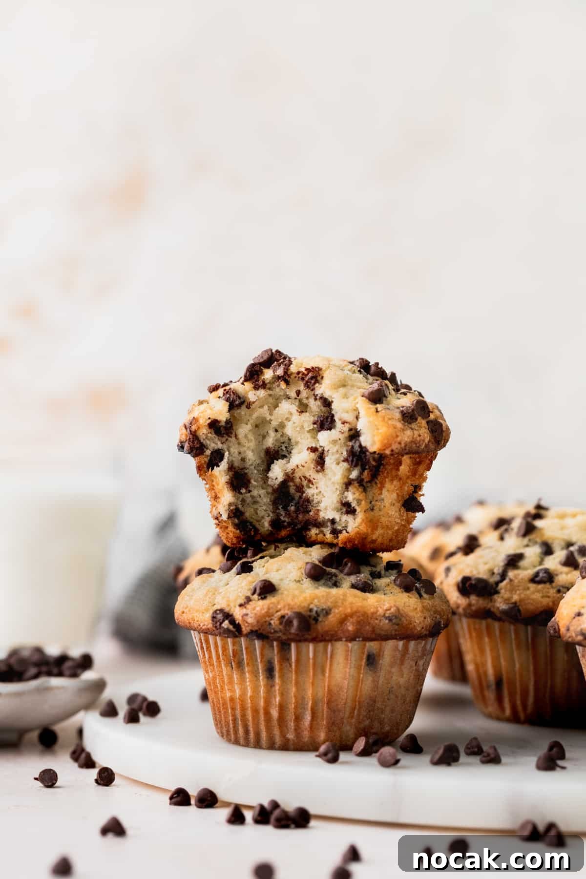 Two muffins stacked on top of each other with one missing a bite.