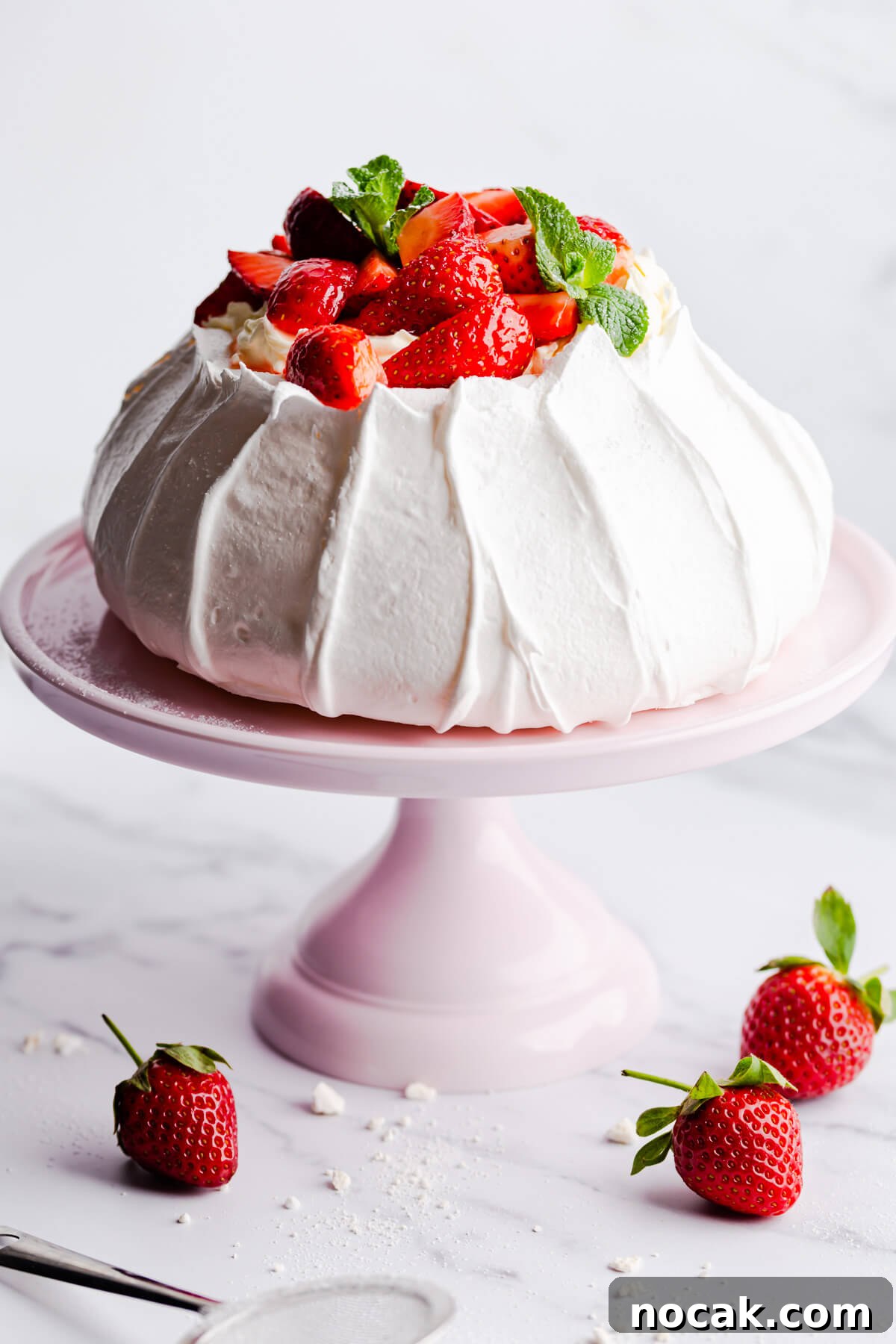 Strawberry Pavlova Recipe: Crisp Meringue with Fresh Berries 2 side close up at a baked pavlova topped with cream and fresh strawberries