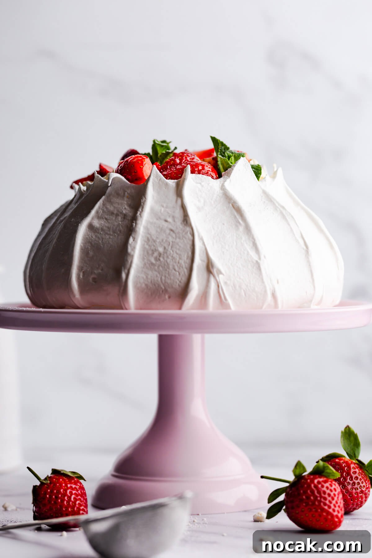 Strawberry Pavlova Recipe: Crisp Meringue with Fresh Berries 8 straight ahead view of the pavlova meringue on a pink cake stand