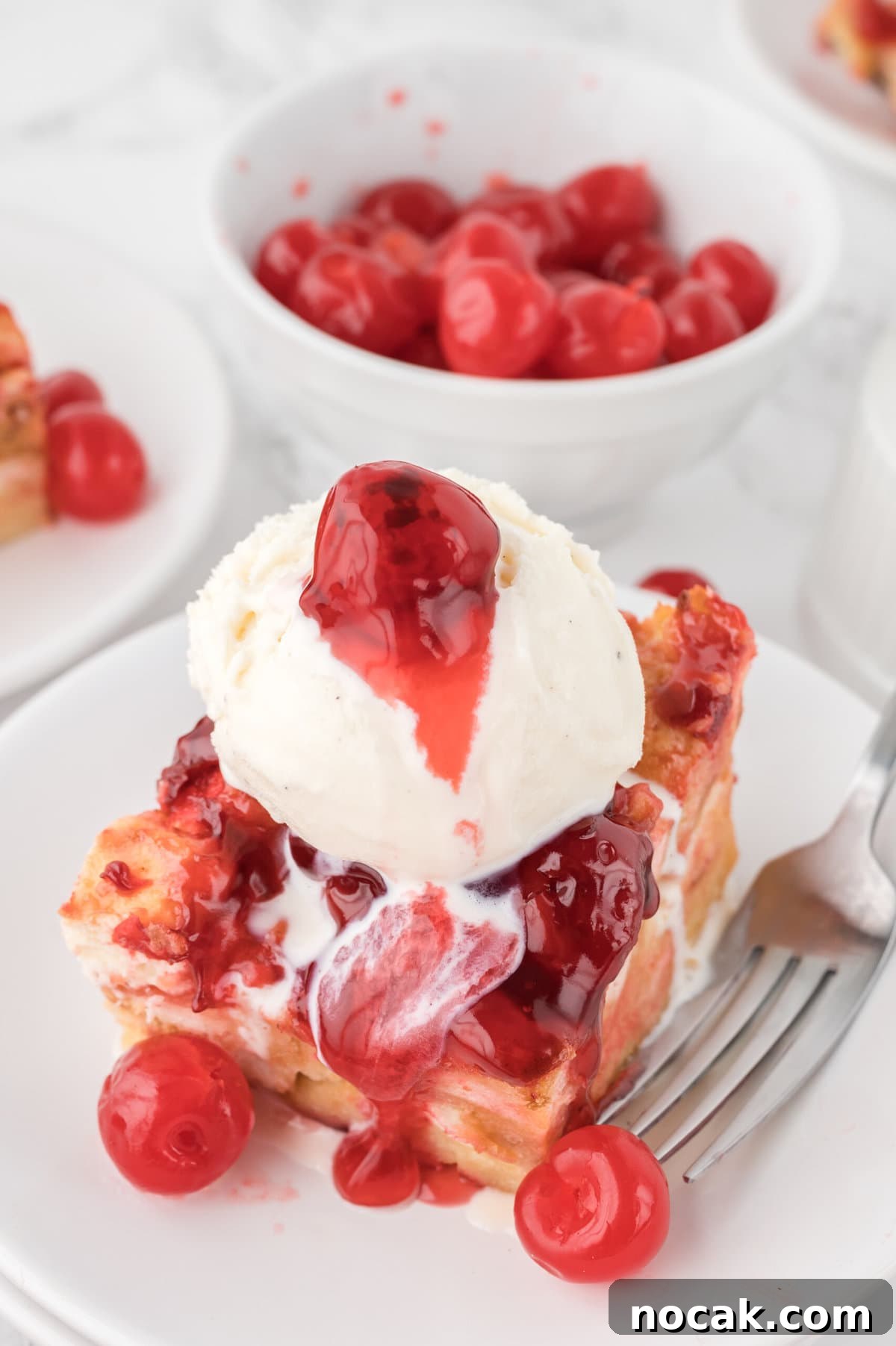 Cherry Bread Pudding Recipe with Fresh Cherry Sauce 2 The recipe with a scoop of ice cream on top.
