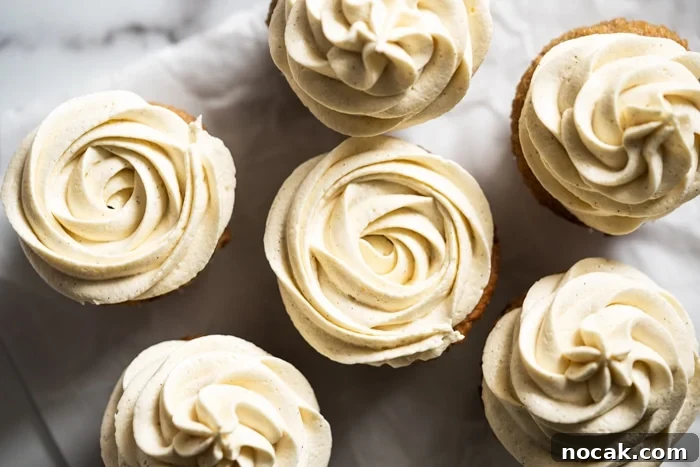 Keto Vanilla Cupcakes: Fluffy Gluten-Free Paleo Recipe 3 Keto cream cheese buttercream frosting piped unto vanilla cupcakes