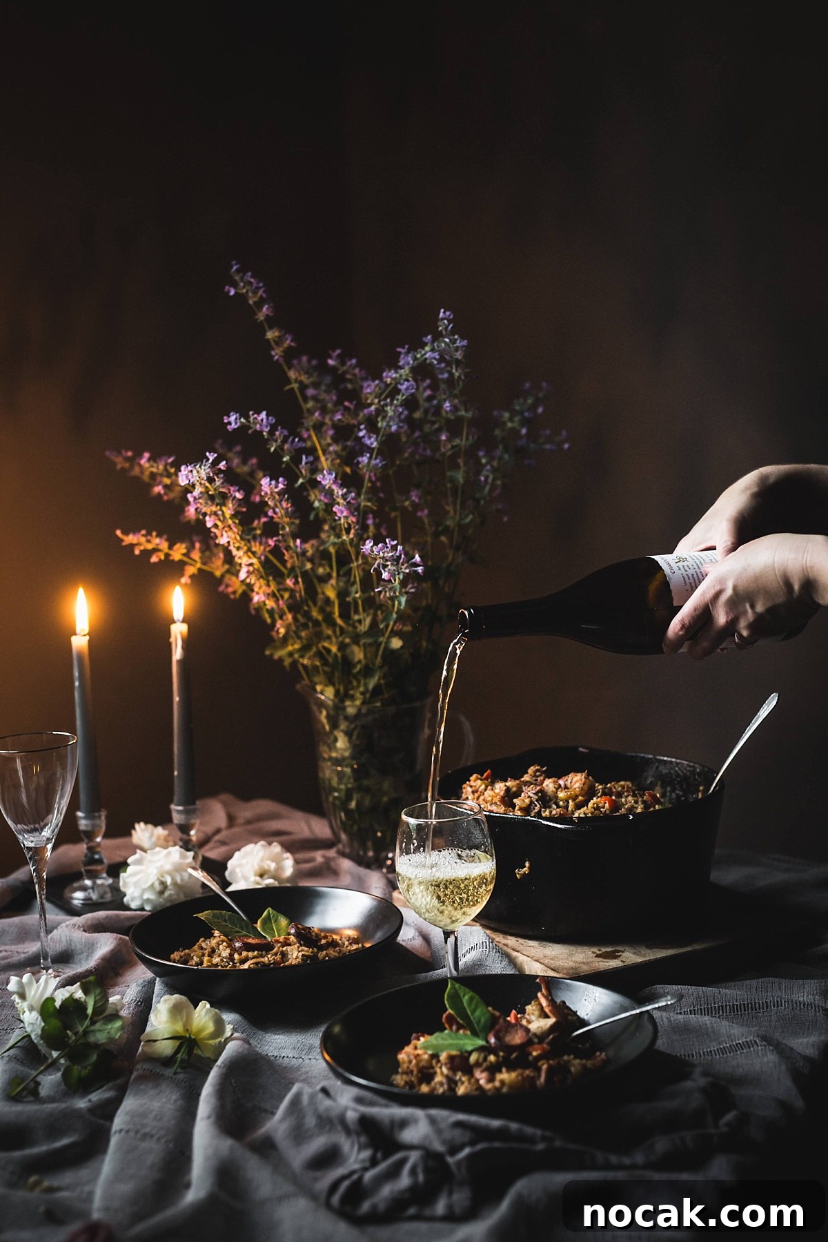Paul Prudhomme’s Dutch Oven Jambalaya Recipe 9 moody image of hands pouring white wine to pair with high end Jambalaya from Commander's Palace