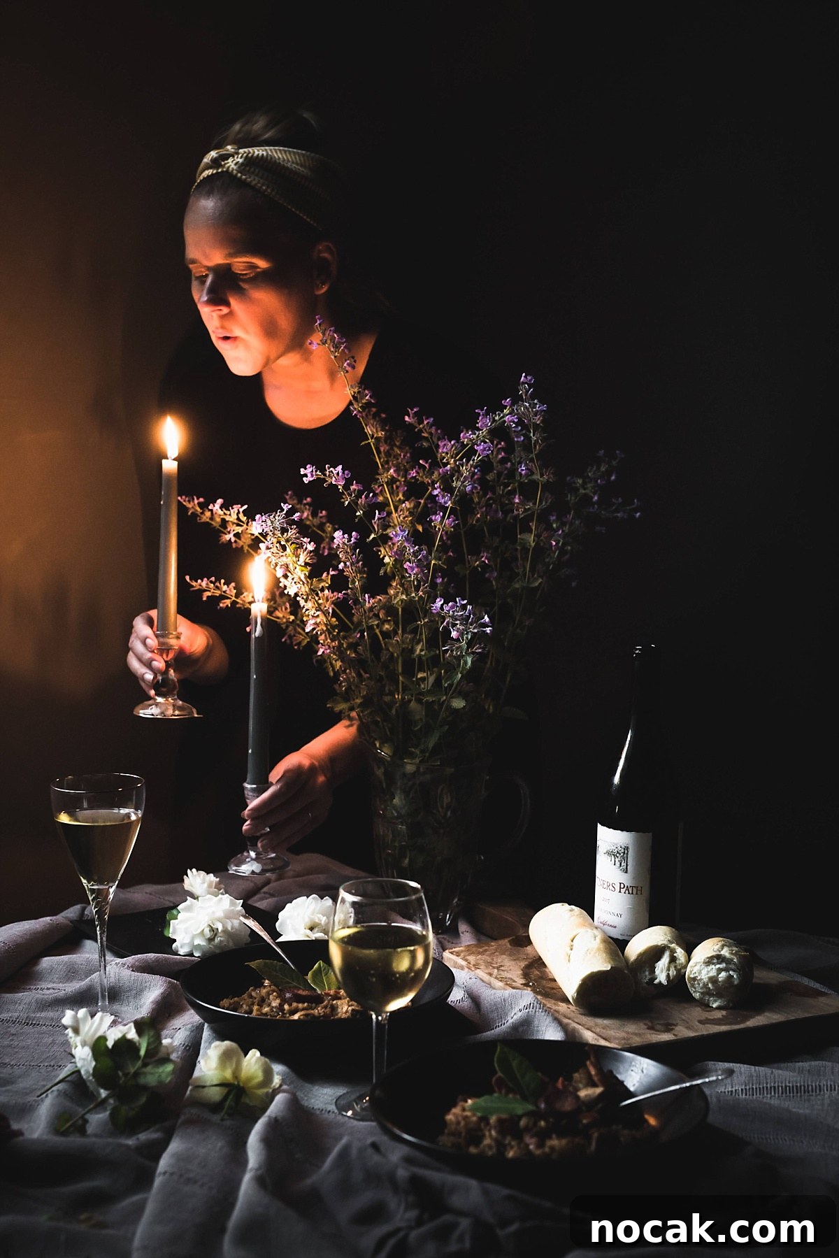 Paul Prudhomme’s Dutch Oven Jambalaya Recipe 11 shadowy image of woman blowing out candles over scene of Jambalaya, wine, crusty bread, and white roses