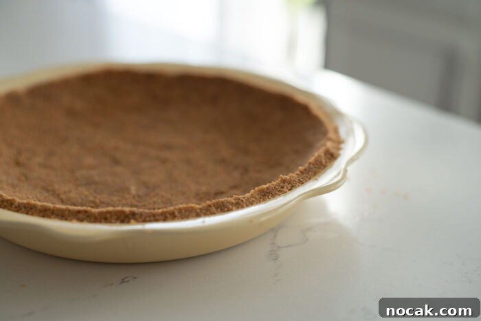 Classic Banoffee Pie Recipe: Creamy Toffee Banana Dessert 6 Graham cookie crumbs are pressed into a yellow pie dish