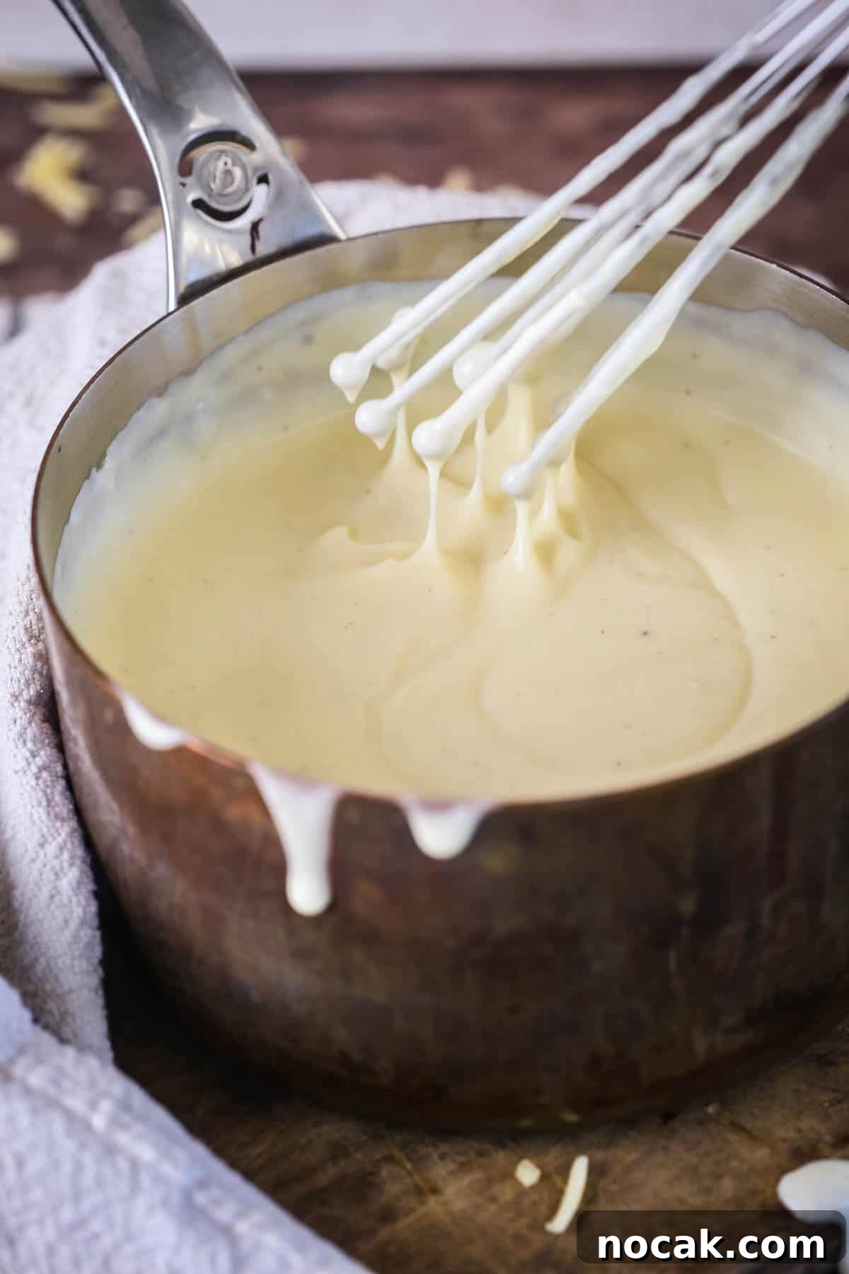 Creamy Gluten-Free Cheese Sauce Recipe for Dips & Pasta 8 Spooning gluten-free cheese sauce from saucepan showing velvety creamy texture.