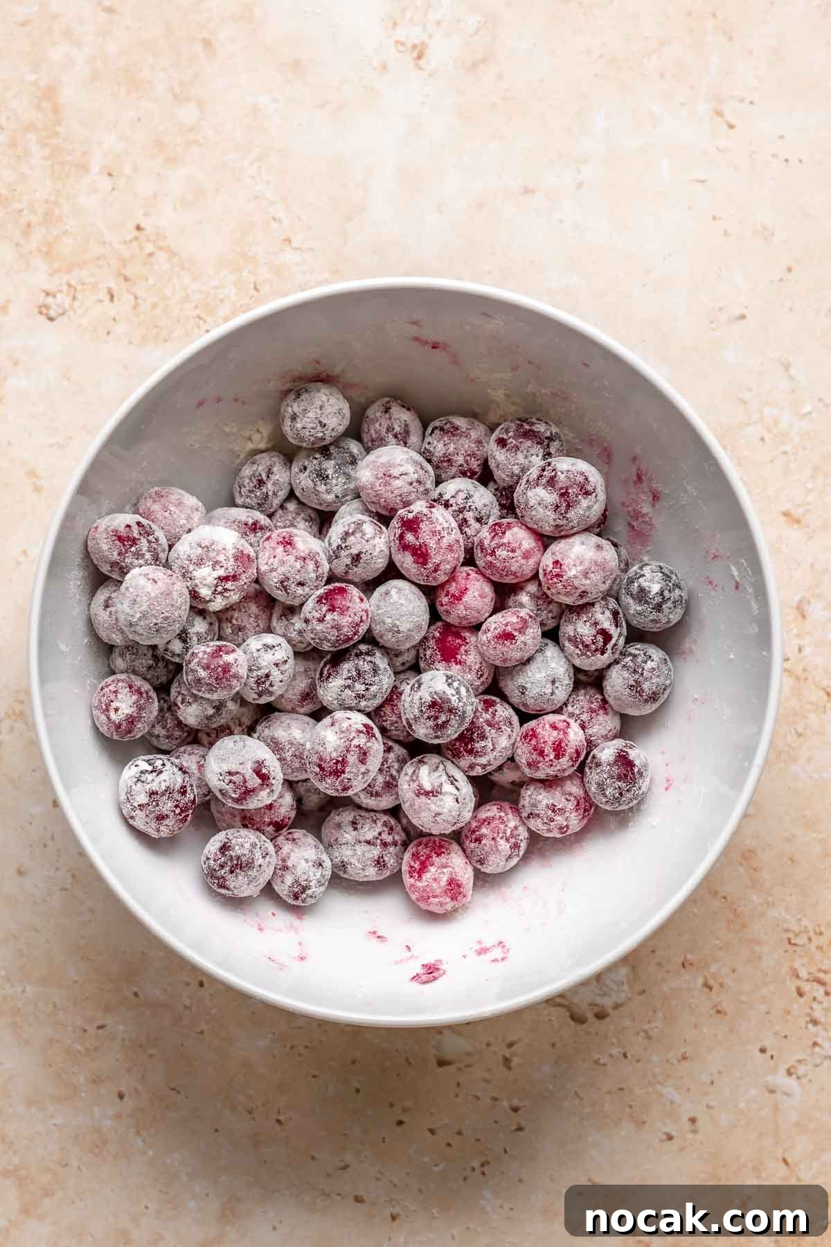 Cranberry Banana Bread Recipe with Zesty Orange Glaze 11 Whole cranberries tossed in a flour in a bowl.