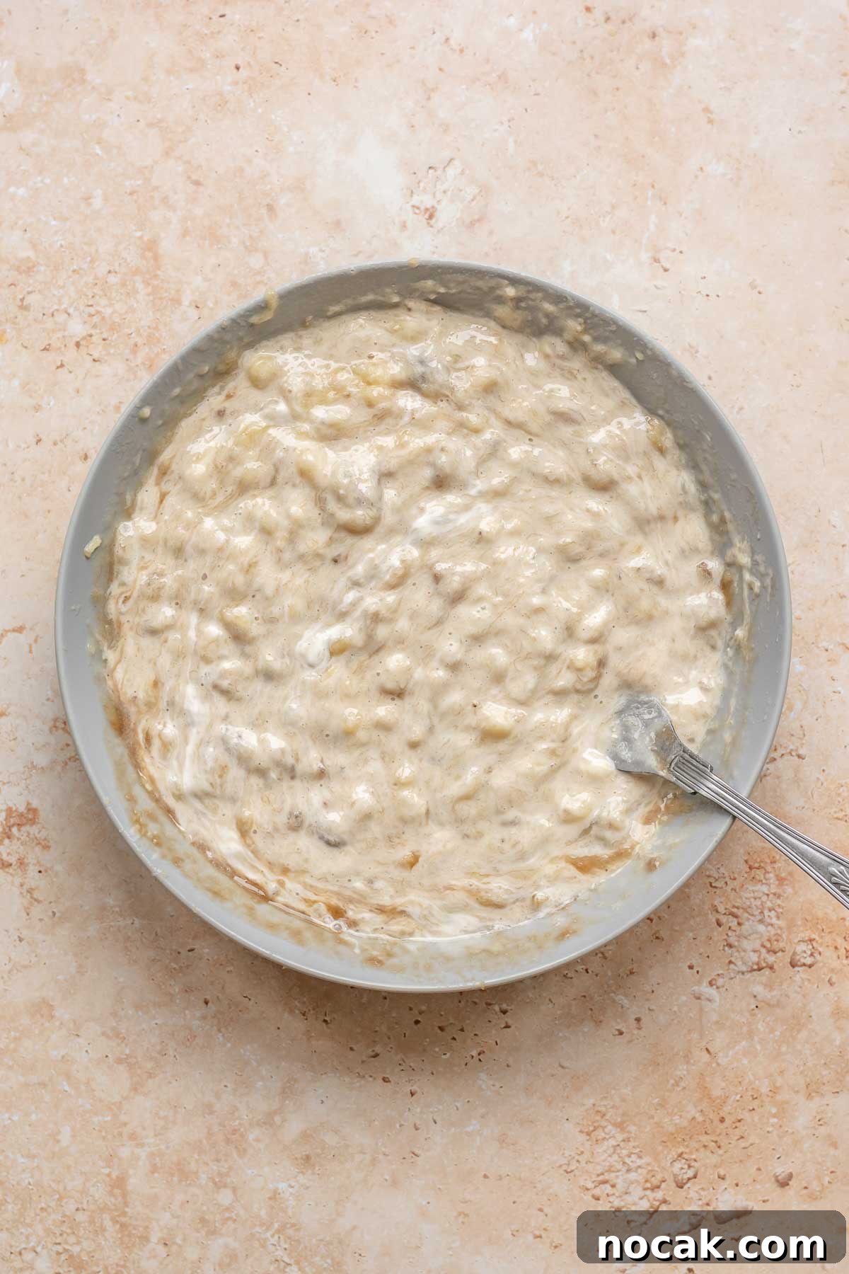 Cranberry Banana Bread Recipe with Zesty Orange Glaze 5 Banans and sour cream mixed in a bowl.