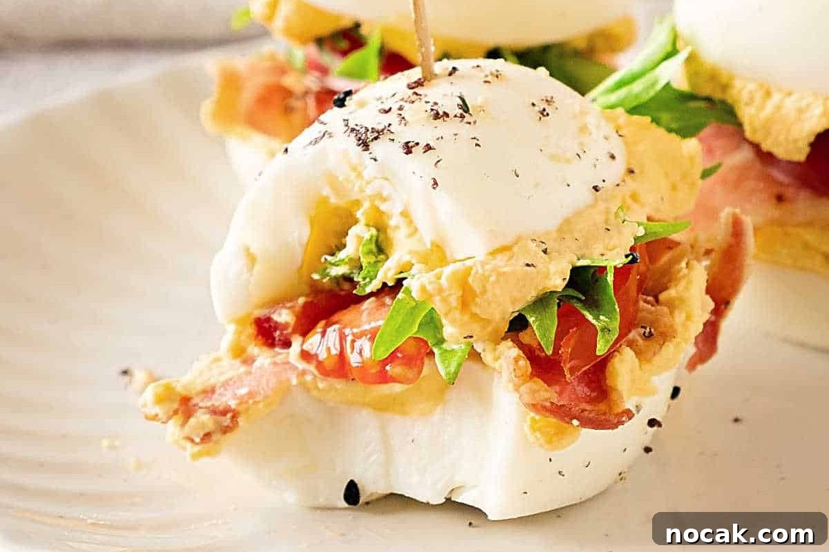 35 Easter Appetizers to Kick Off Your Holiday Feast 16 An Easter appetizer of a poached egg on a bacon and avocado sandwich with a sprinkle of black pepper.