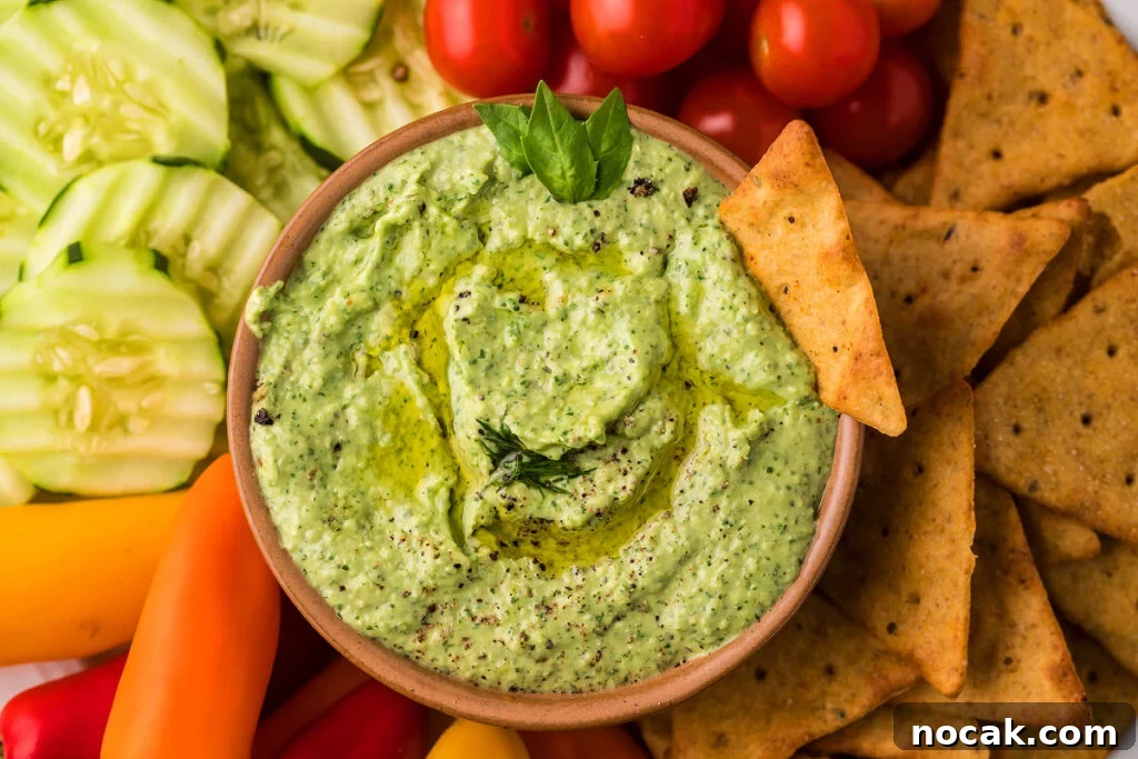 35 Easter Appetizers to Kick Off Your Holiday Feast 3 Side view of avocado herb green dip with vegatbles on the side.