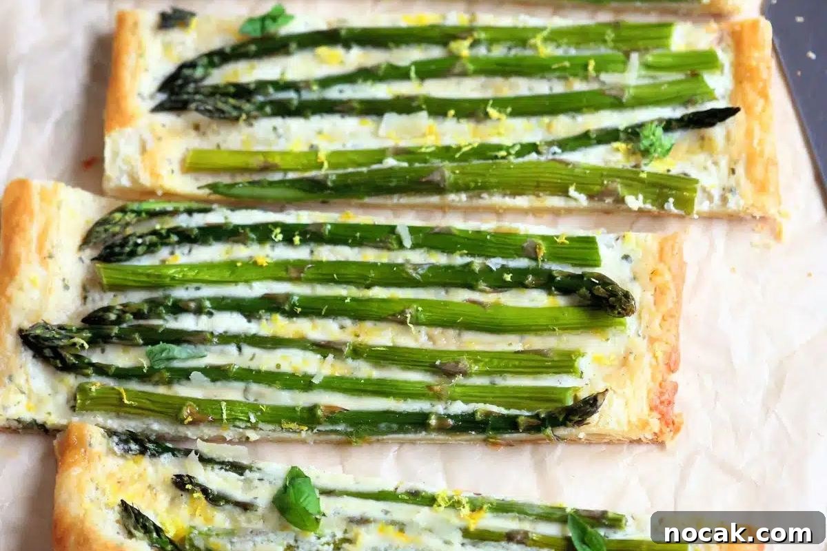 35 Easter Appetizers to Kick Off Your Holiday Feast 23 Two asparagus tarts on parchment paper, perfect for an Easter appetizer.