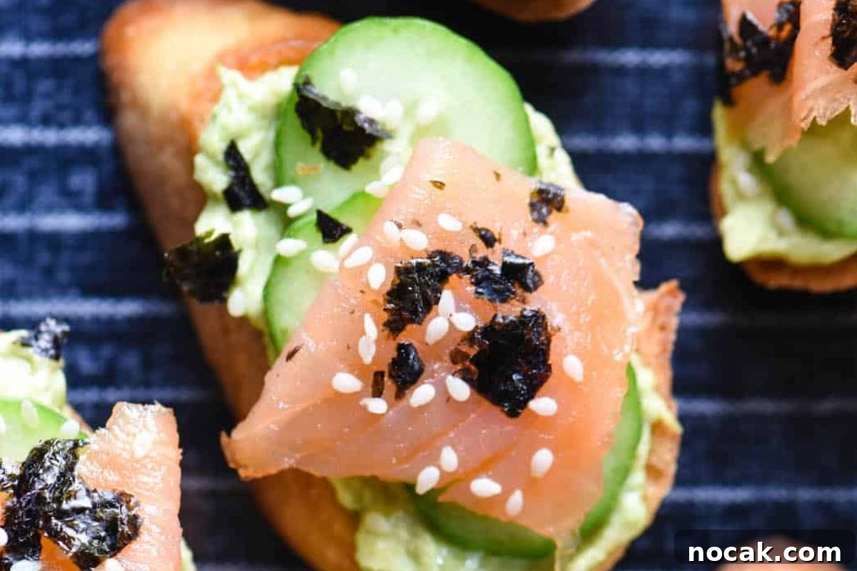 35 Easter Appetizers to Kick Off Your Holiday Feast 25 Close-up of an Easter appetizer featuring smoked salmon and avocado toast garnished with sesame seeds and seaweed.