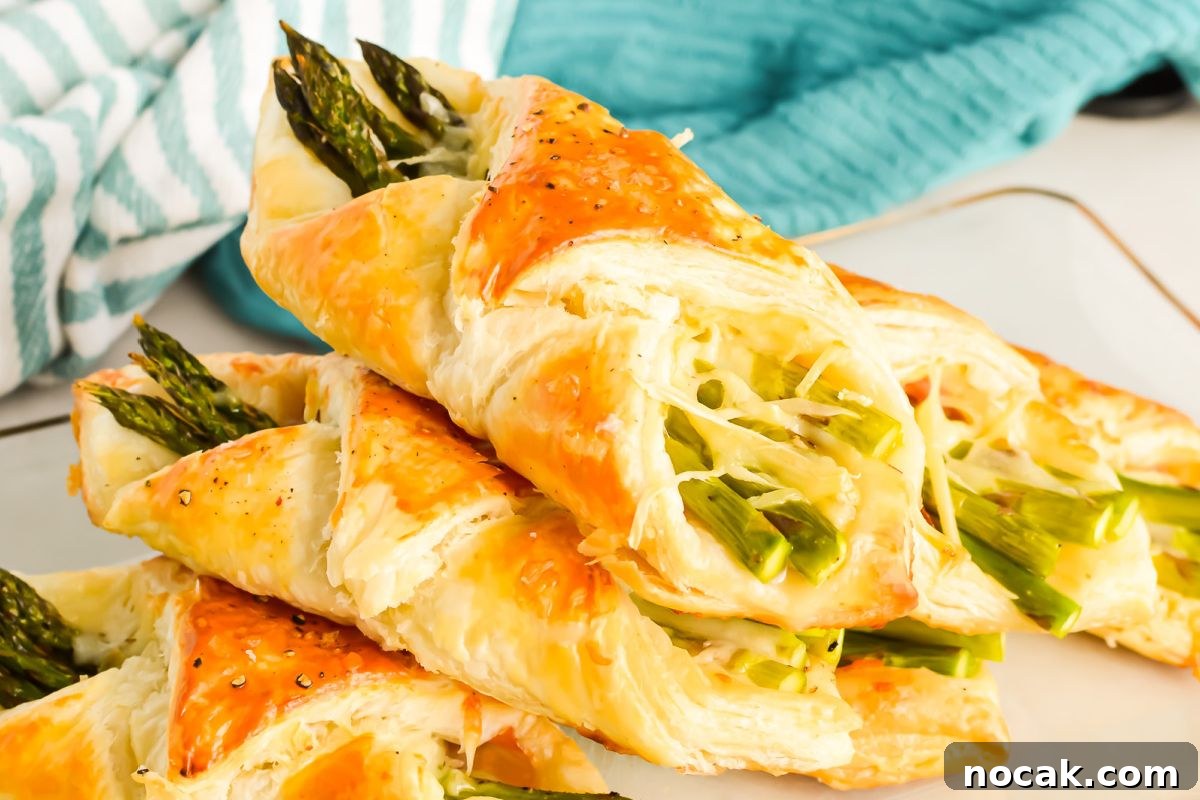 35 Easter Appetizers to Kick Off Your Holiday Feast 27 Freshly baked asparagus pastry twists on a white surface, perfect as an Easter appetizer.
