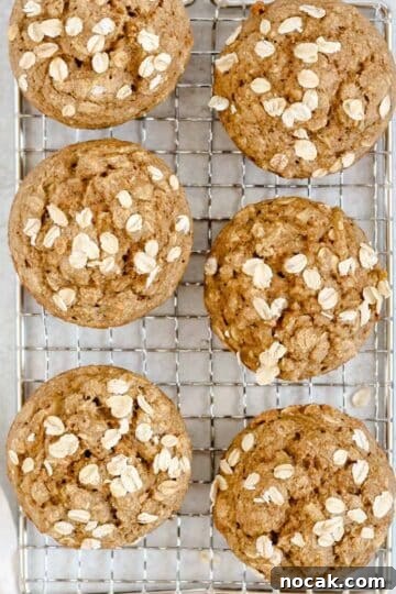Apple cinnamon oat muffins on a wire cooling rack.