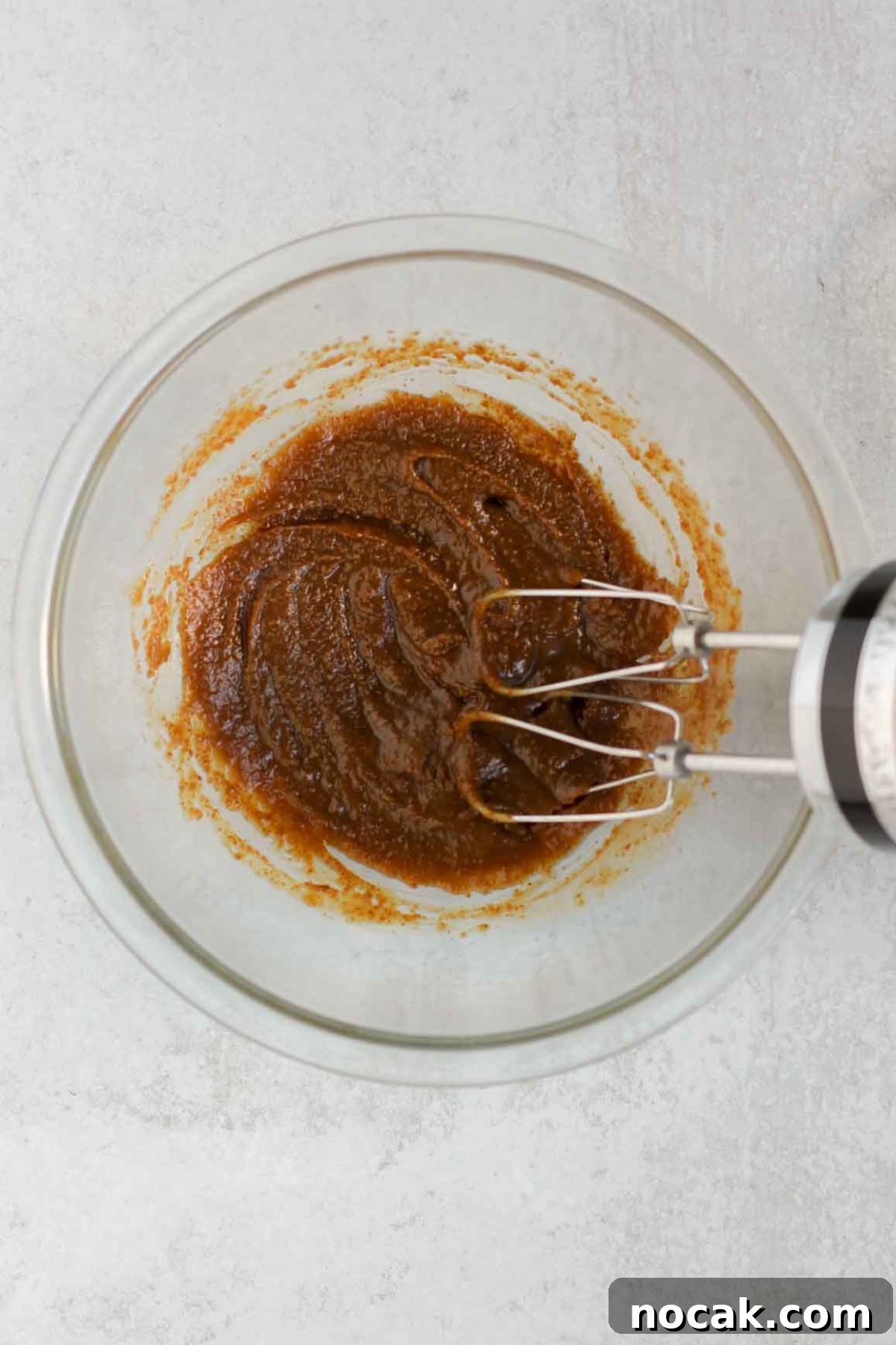 Butter and coconut sugar mixed together in a glass mixing bowl.