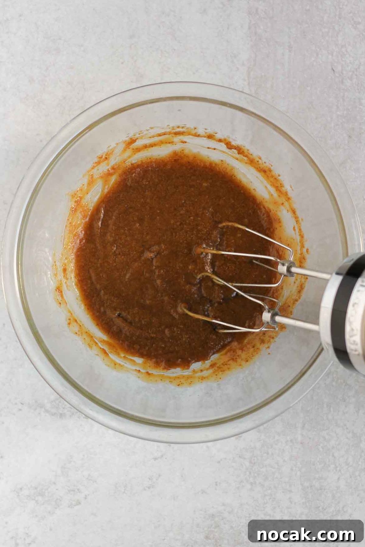Butter, coconut sugar, eggs, and vanilla mixed in a glass mixing bowl.