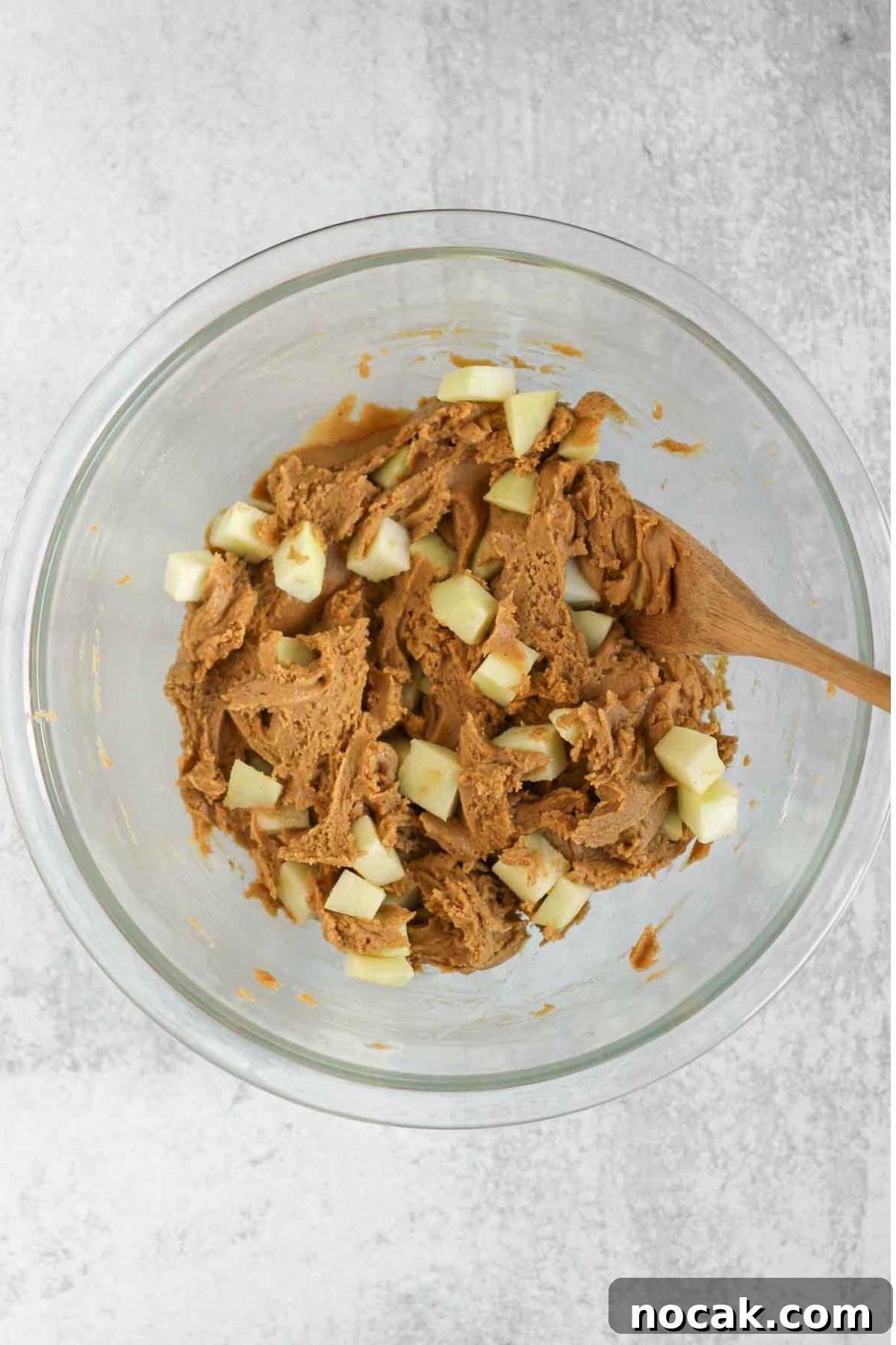 Gluten-free apple blondie batter being mixed in a glass mixing bowl.