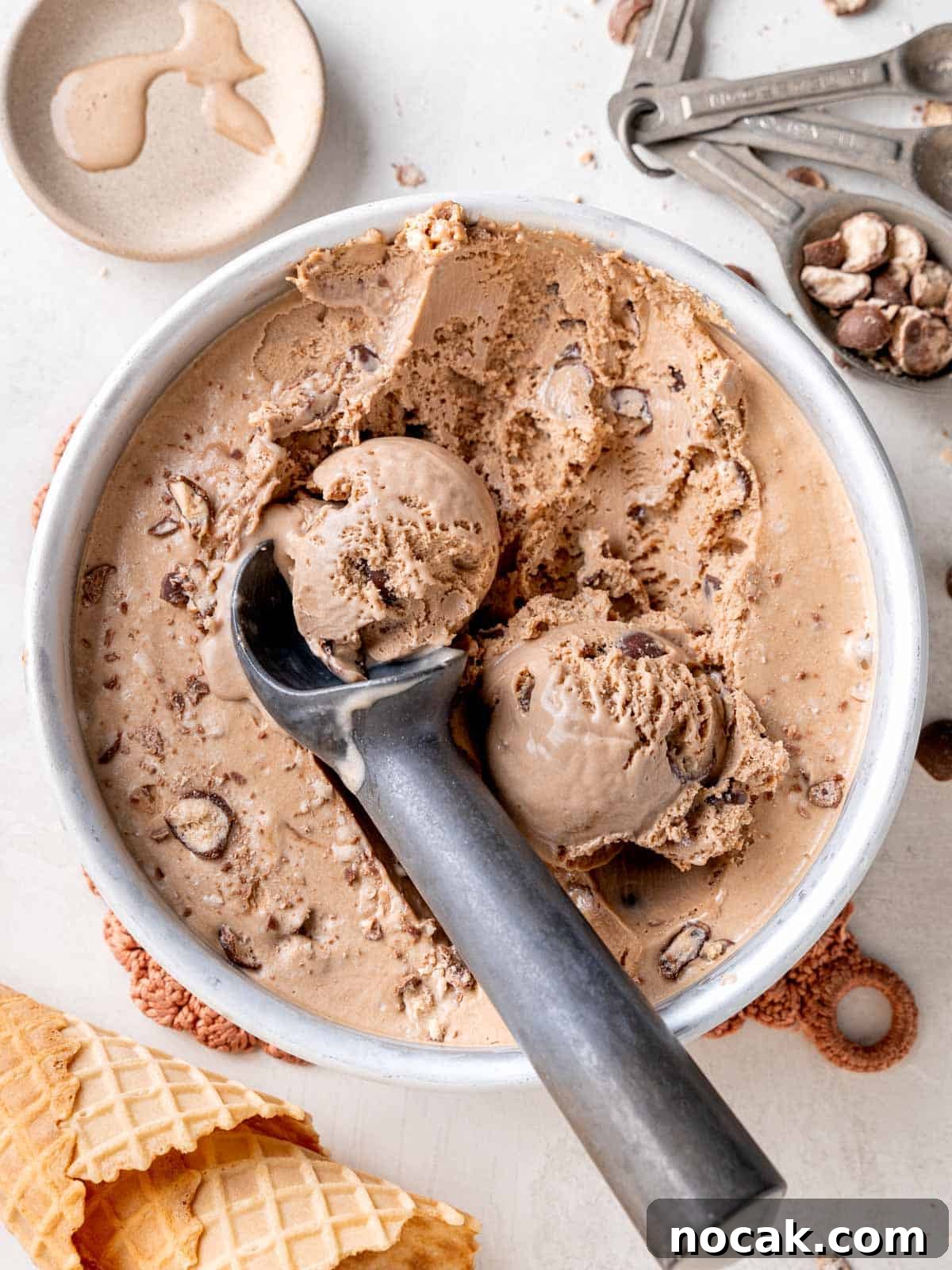 Chocolate Malted Crunch Ice Cream Recipe: Creamy Malted Chocolate with Crispy Crunch 12 Top view of scoops of malted chocolate ice cream with Whoppers in a round pan.