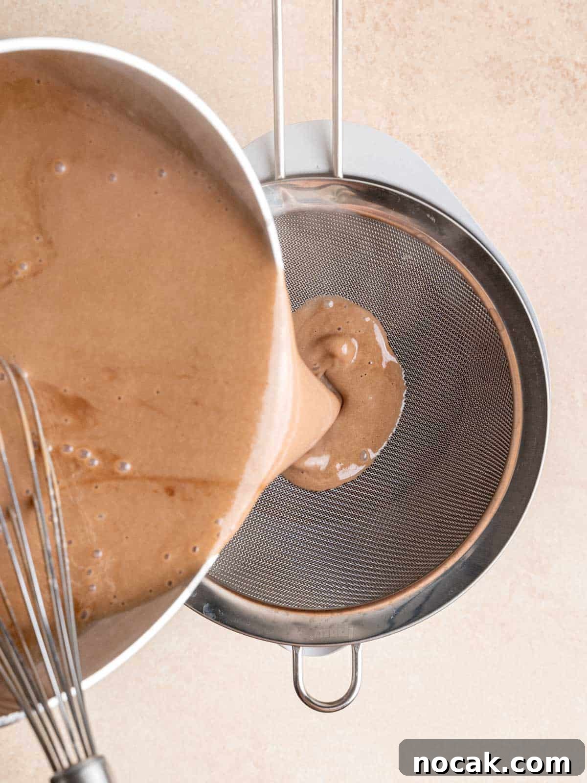Chocolate Malted Crunch Ice Cream Recipe: Creamy Malted Chocolate with Crispy Crunch 9 Pouring the malt chocolate ice cream mixture into a bowl through a fine mesh sieve.
