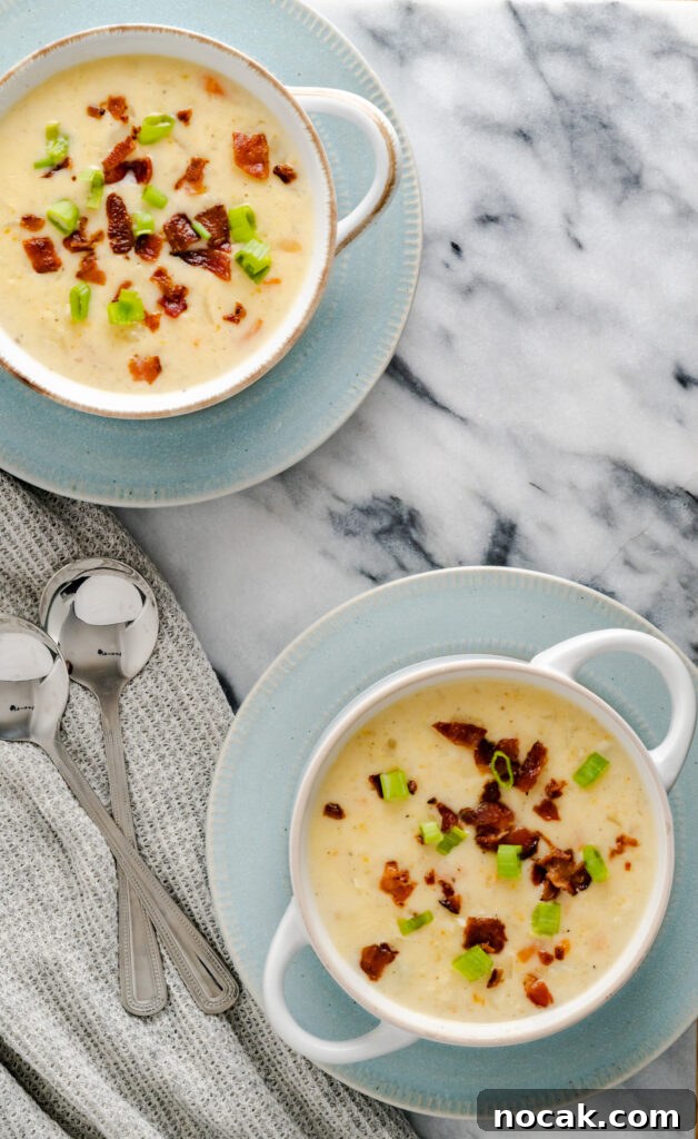 Creamy Instant Pot Cauliflower and Potato Soup Recipe 3 Instant pot gluten-free cauliflower potato soup served in white-rimmed bowls sitting on blue plates.