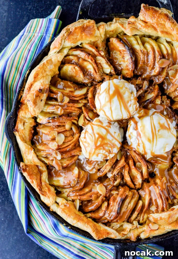 Rustic Apple Galette with Flaky Puff Pastry 2 Caramel Apple Galette with a puff pastry crust in a cast iron pan. Three dollops of ice cream are on top. A blue striped napkin sits next to it.