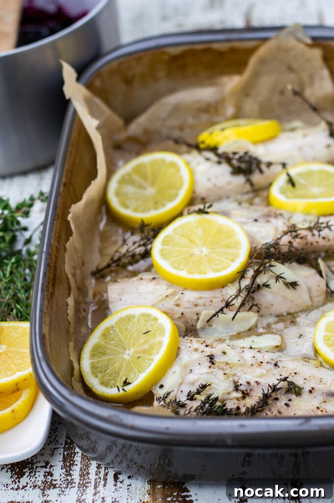 Oven-Baked Mahi Mahi with Blueberry Glaze 6 A roasting pan of baked mahi mahi. Lemon slices and thyme sprigs sit on top of the fish.