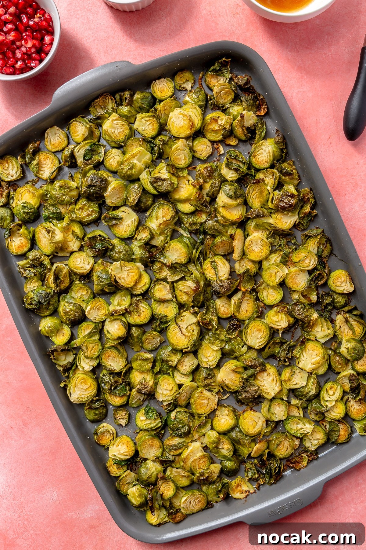 Roasted Brussels Sprouts and Pomegranate Salad with Citrus Vinaigrette 5 Roasted, crispy, golden-brown brussels sprouts sit on a baking tray.