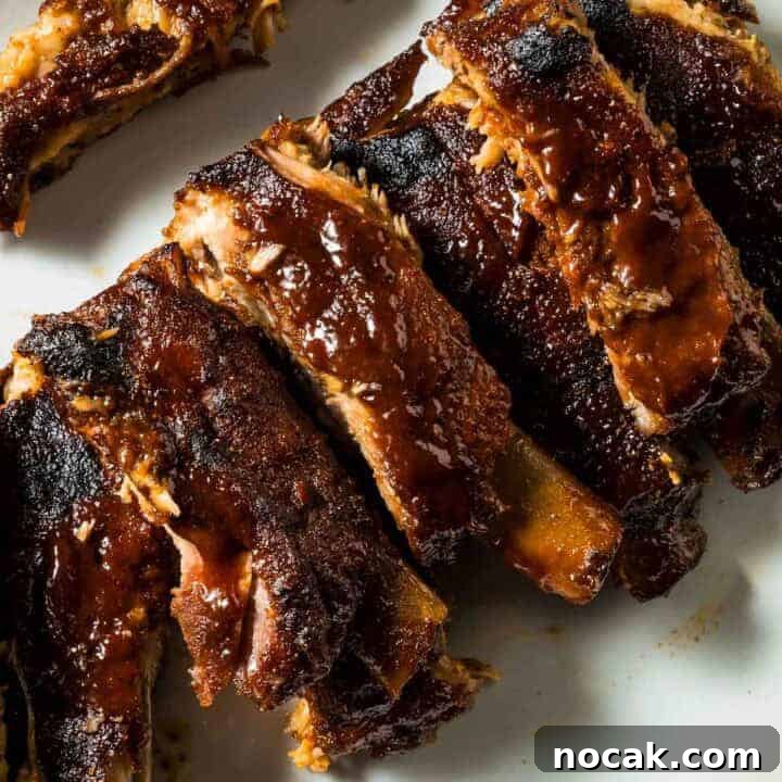 a closeup of st louis style oven-baked ribs just out of the oven on a white plate