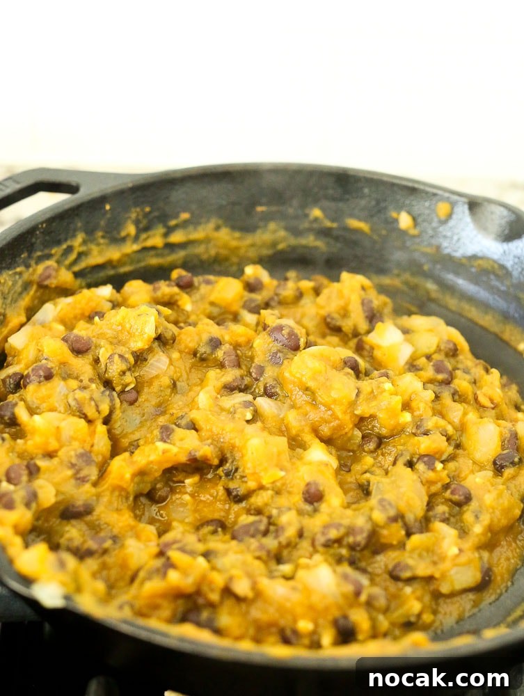 Preparing the mixture for ButternutSquash Black Bean Enchiladas recipe--ingredients mixed together in pan