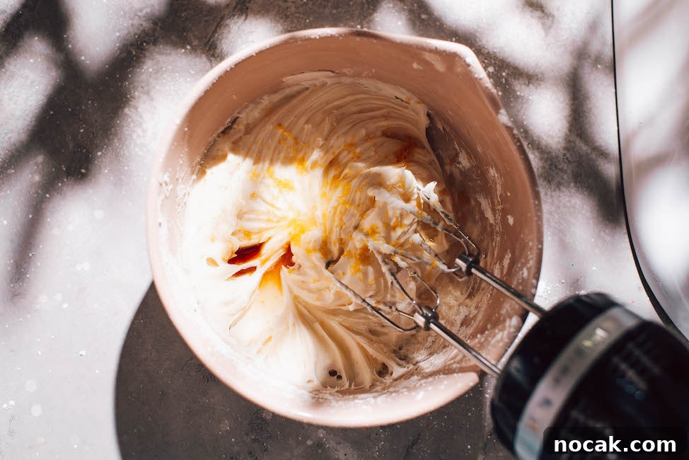 Soft Chewy Lemon Sugar Cookies Recipe for Perfect Texture 7 lemon cream cheese buttercream in light pink mixing bowl.