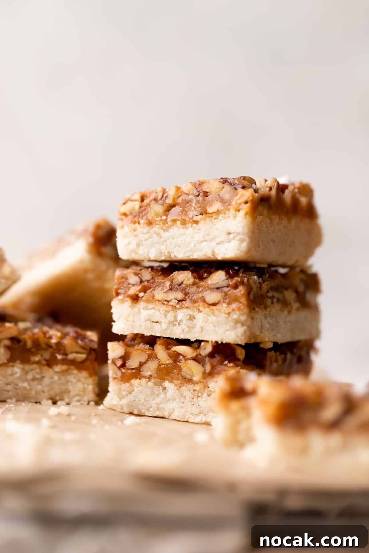 Salted Caramel Pecan Bars Recipe — Chewy Pecan Caramel Squares 2 three caramel pecan bars stacked on top of each other.