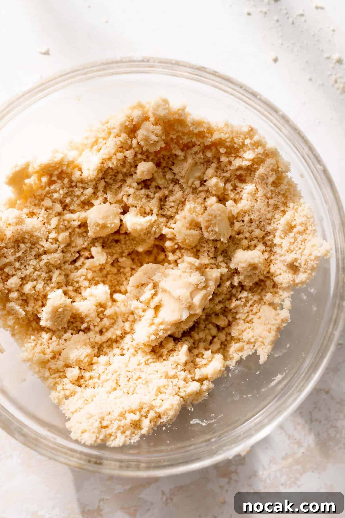 Salted Caramel Pecan Bars Recipe — Chewy Pecan Caramel Squares 5 a glass bowl with the shortbread crumbs.
