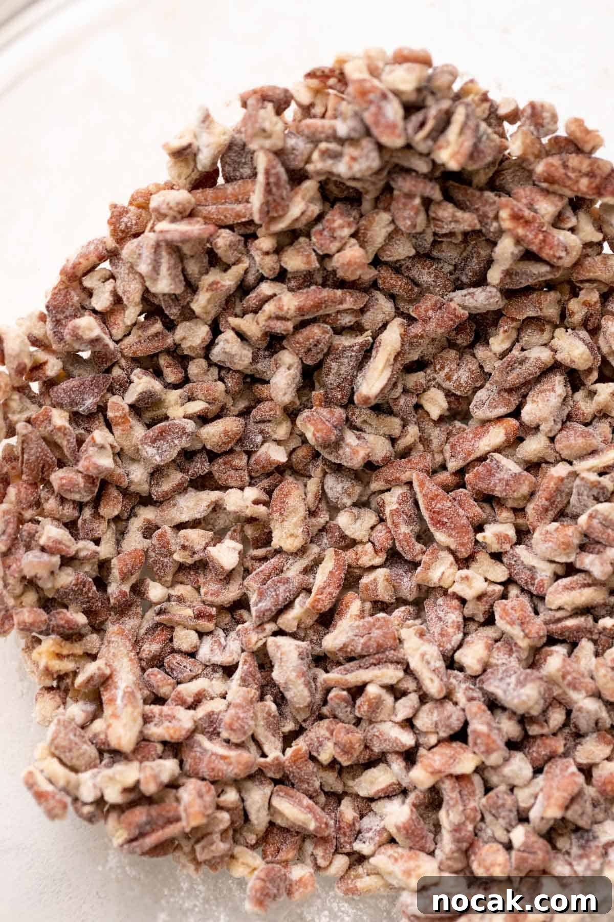 Salted Caramel Pecan Bars Recipe — Chewy Pecan Caramel Squares 7 a bowl of pecans that have been tossed in flour.