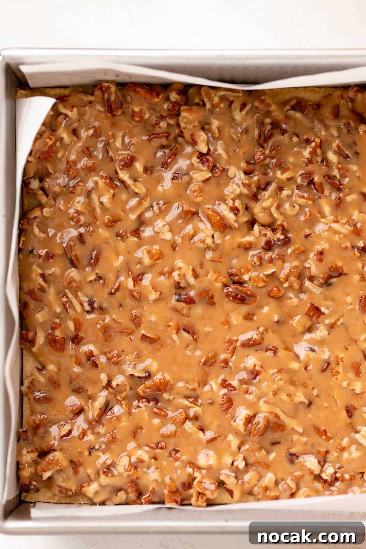 Salted Caramel Pecan Bars Recipe — Chewy Pecan Caramel Squares 9 the caramel pecan bars in a baking pan before baking.