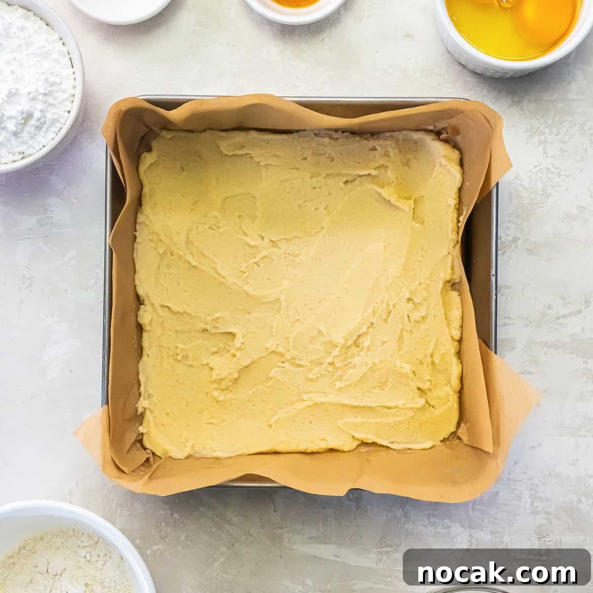 Chewy Apricot Bars with Oat Crust and Almond Glaze 8 Shortbread-style crust pressed into a parchment-lined square baking pan.