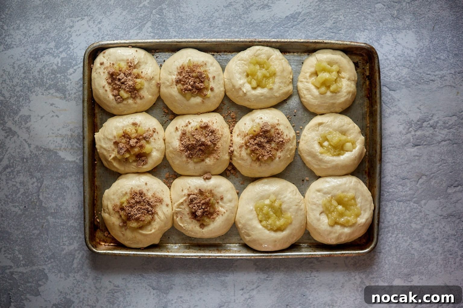 Homemade Apple Kolache Recipe with Video Tutorial 11 Top down view of apple filled kolaches topped with streusel topping ready to be baked.