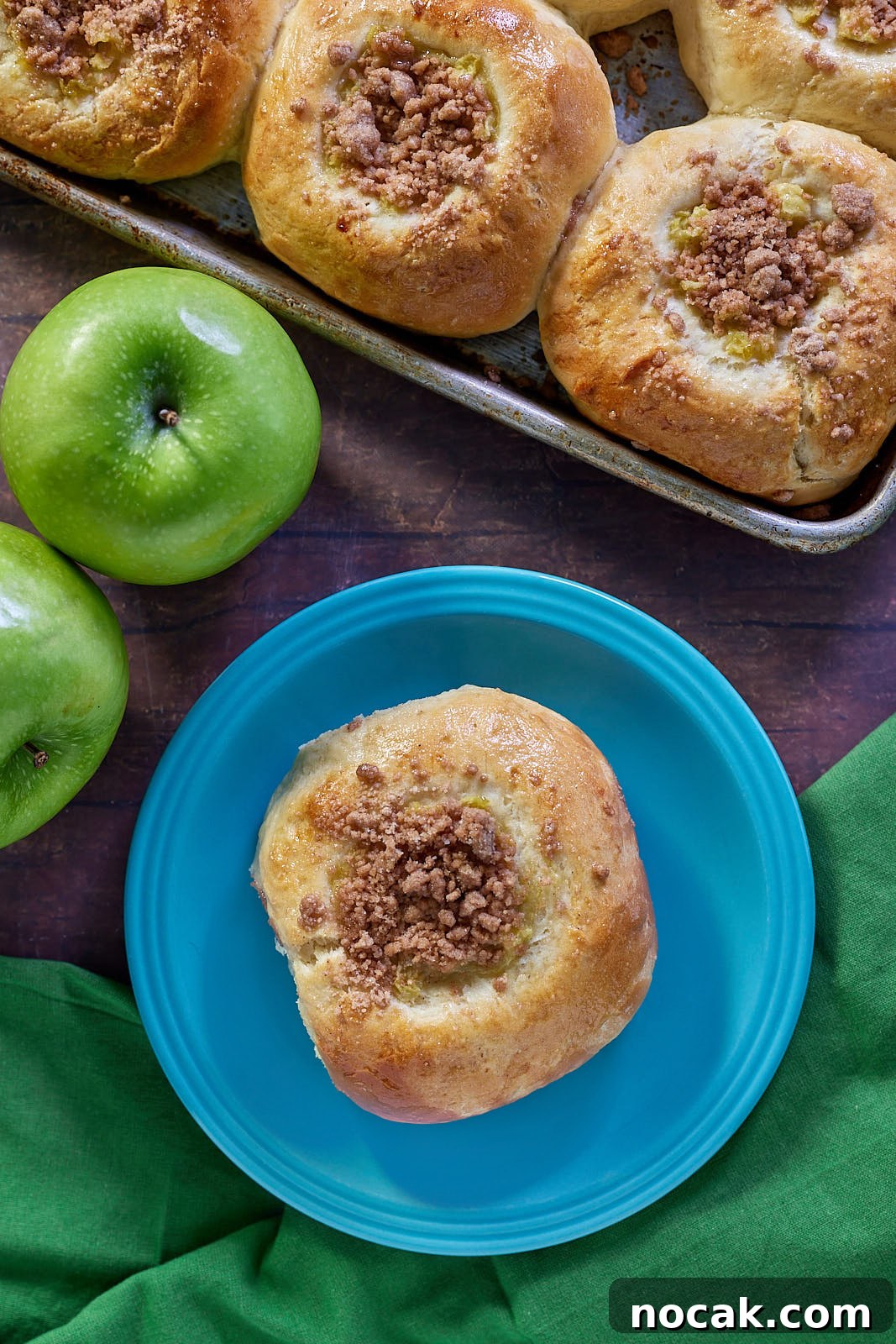Homemade Apple Kolache Recipe with Video Tutorial 12 Apple Kolaches on a tray with one on a plate separated.
