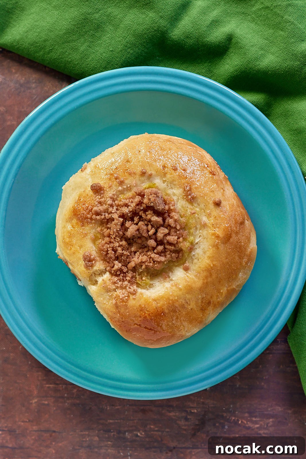 Homemade Apple Kolache Recipe with Video Tutorial 15 Close-up top-down view of a single apple kolache on a blue plate.
