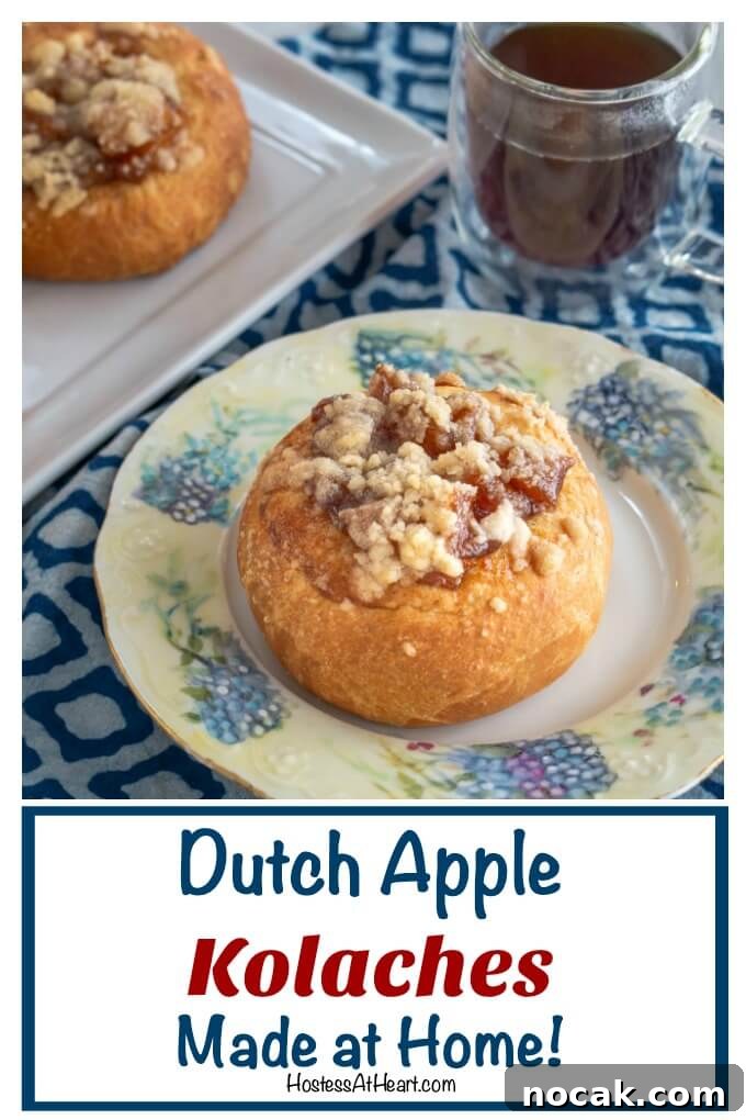 Homemade Apple Kolache Recipe with Video Tutorial 17 Baked roll filled with apple filling and topped with a cinnamon crumble sitting on a floral plate in front of a cup of coffee and tray of rolls.