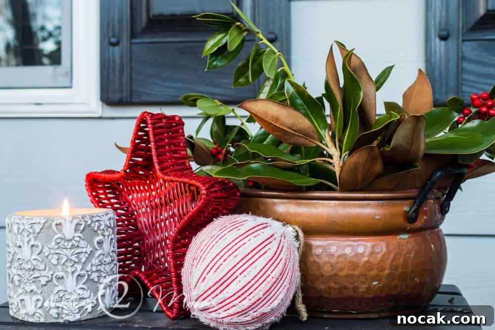copper container with magnolia leaves and red berries, candle, farmhouse fabric ornament, red basket star