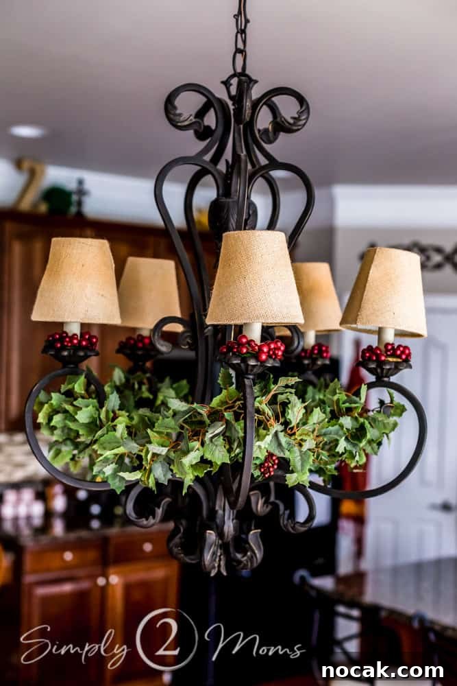 wrought iron chandelier with burlap lamp shades and red berry rings on each candle