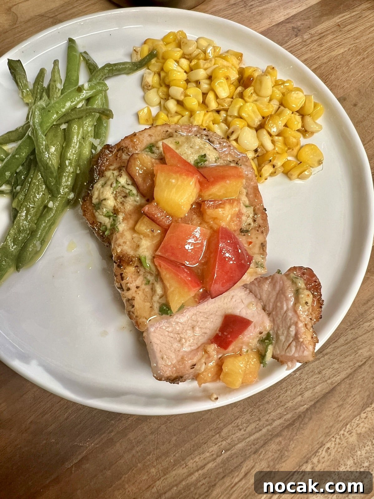 Juicy pork chops with grilled peaches. Grilled pork chops with grilled peaches on a plate with vegetables.